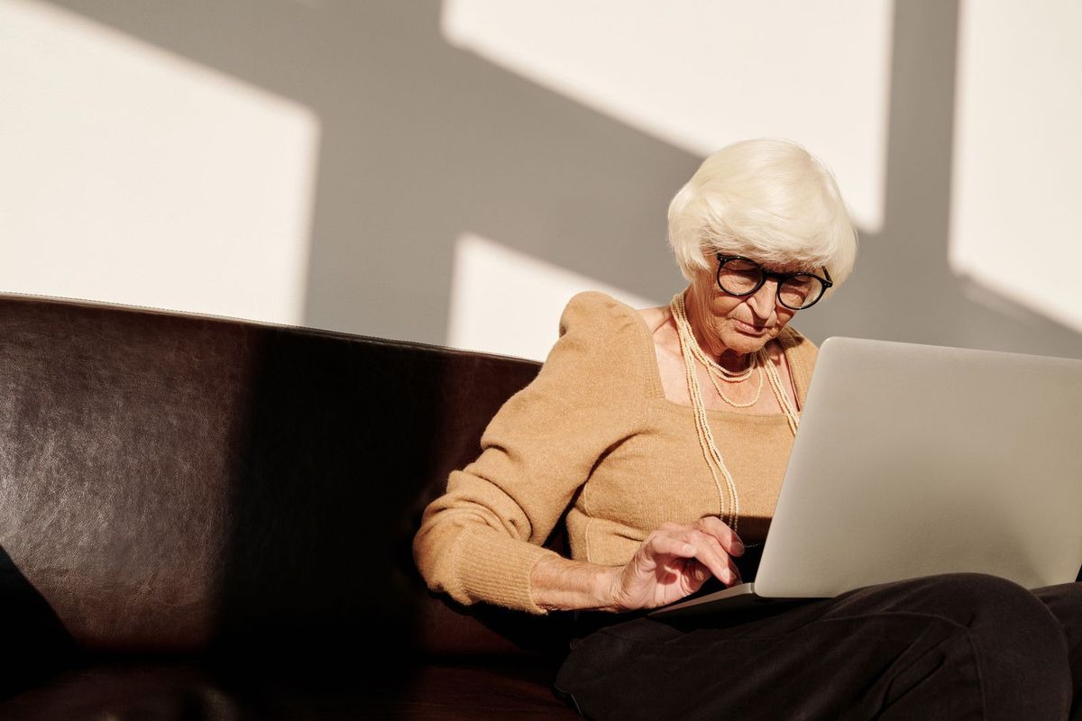 Frau mit Brille vergleicht am Laptop Angebote