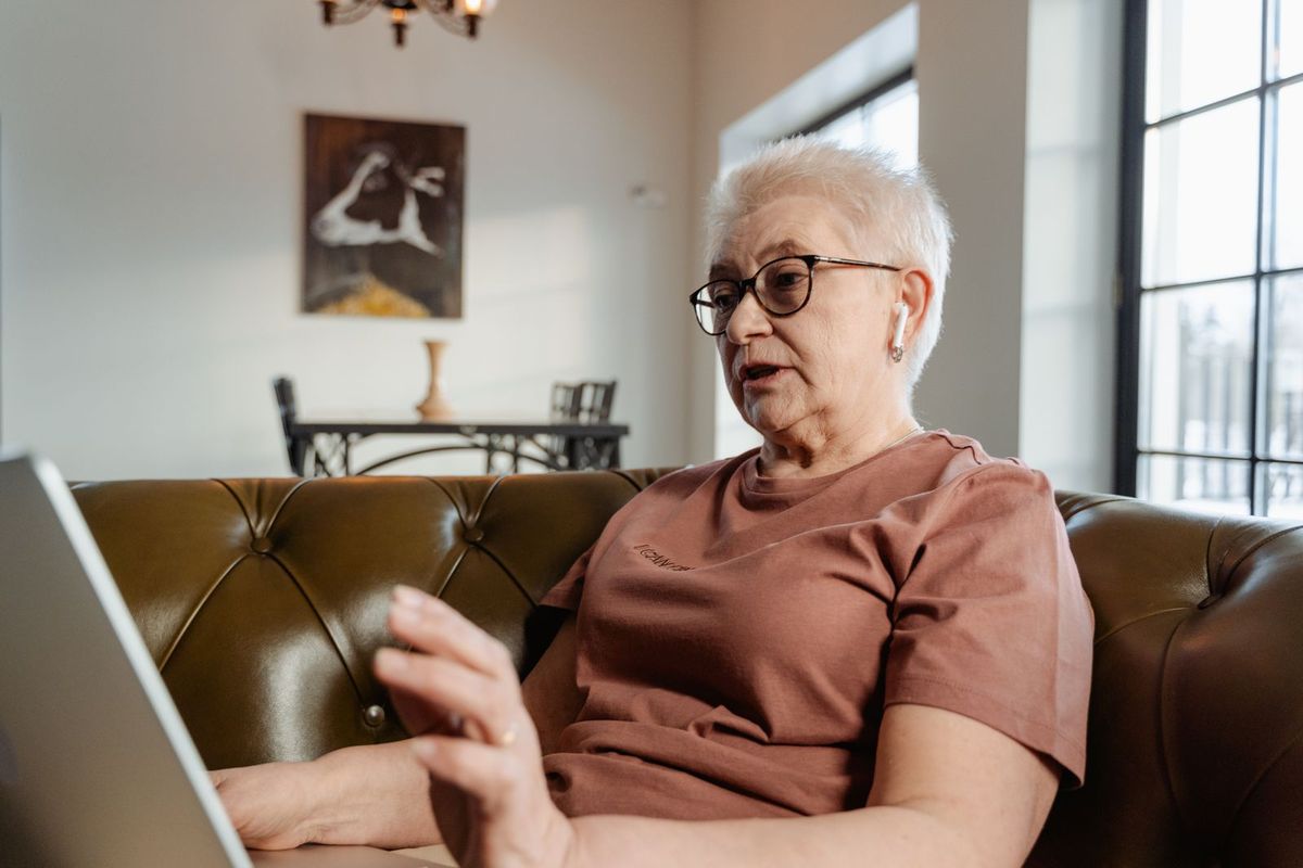 Frau über 70 im Videoanruf am Laptop