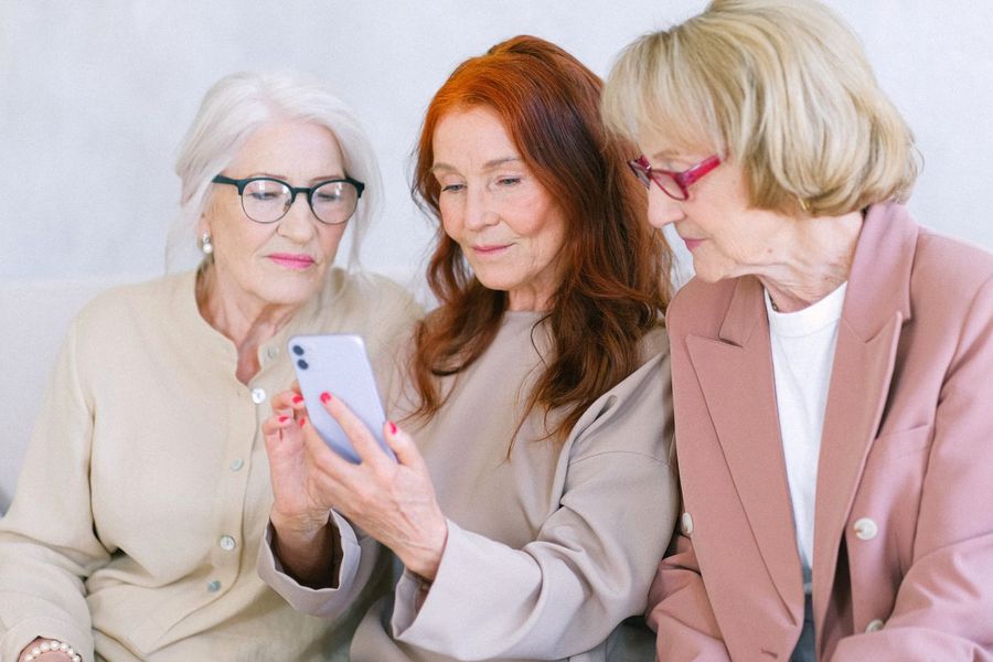 Drei Frauen schauen gemeinsam auf ein Smartphone